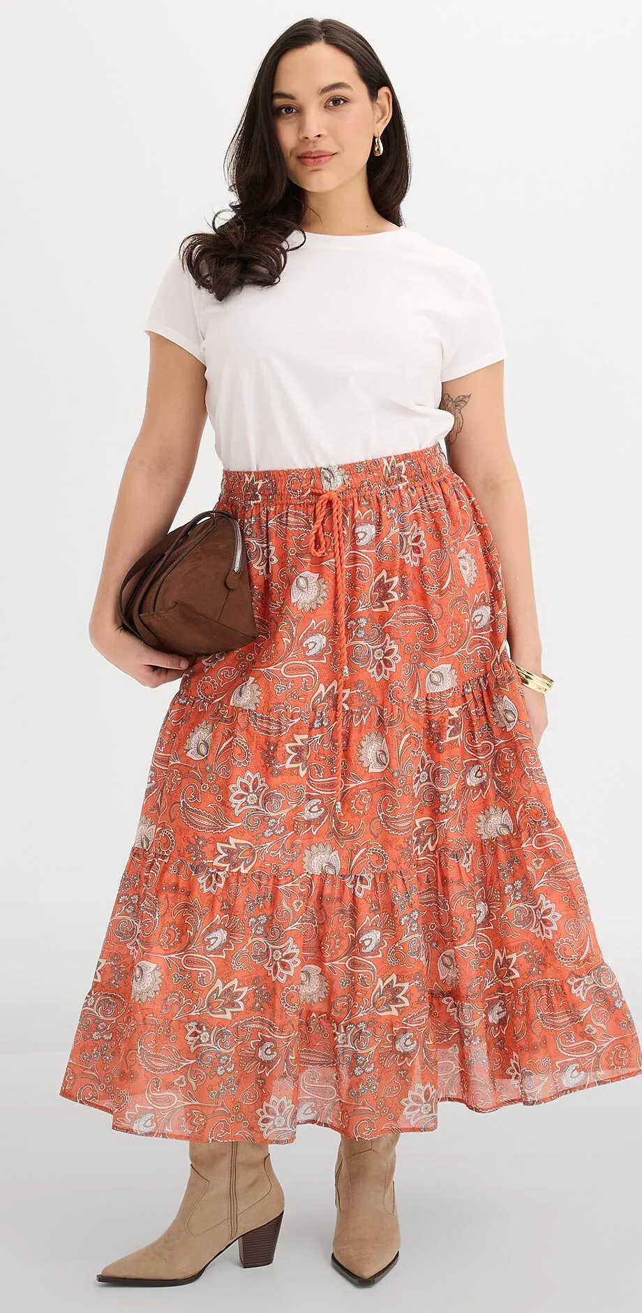 Wei&szlig;es T-Shirt kombiniert mit orangefarbenem, gemustertem Maxirock. 