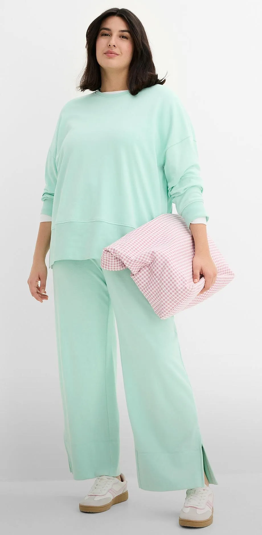 Bequemer mintgr&uuml;ner Freizeitanzug mit weitem Pullover und Hose. 