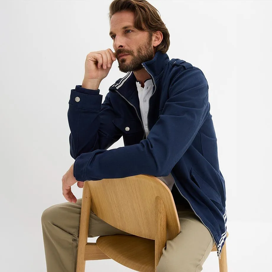 Tenue comprenant une veste bleu marine et une chemise blanche.