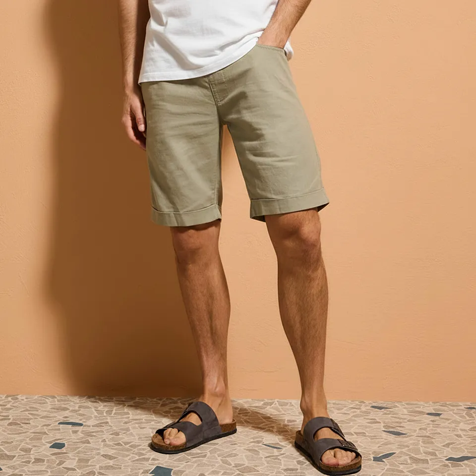 T-shirt blanc, short beige et sandales marron confortables.