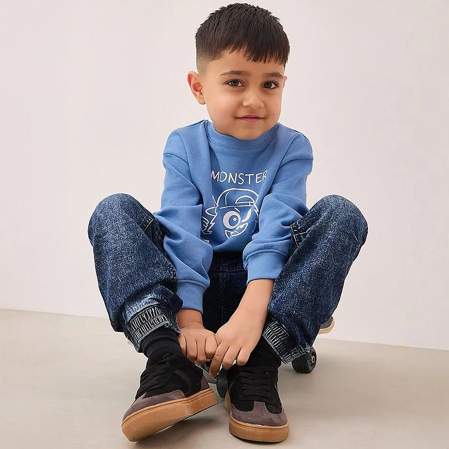 Ein kleiner Junge sitzt auf dem Boden.