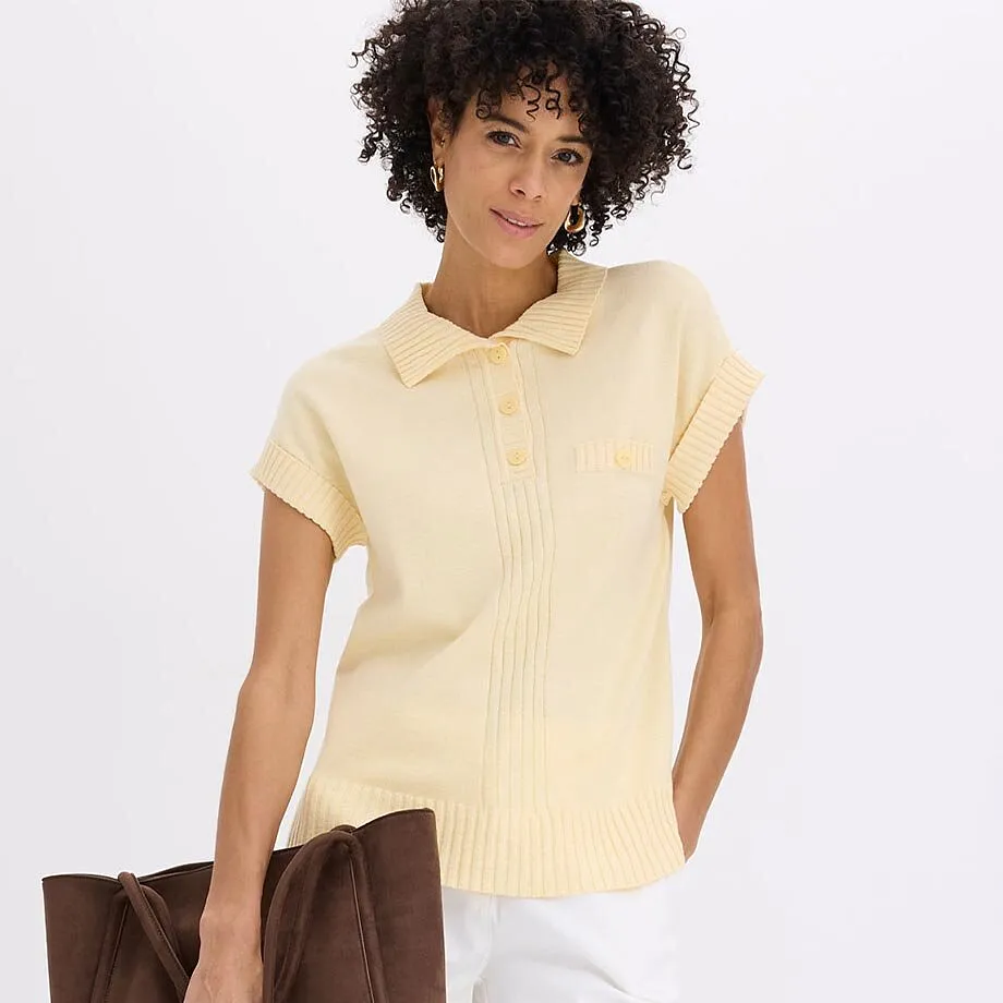 Pull-polo jaune &agrave; manches courtes et pantalon blanc.