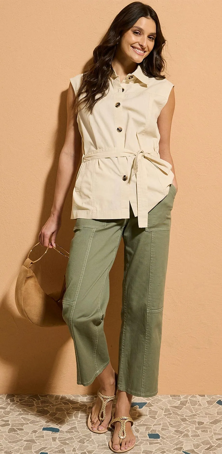 Gilet sans manches beige avec ceinture associ&eacute; &agrave; un pantalon olive en twill.