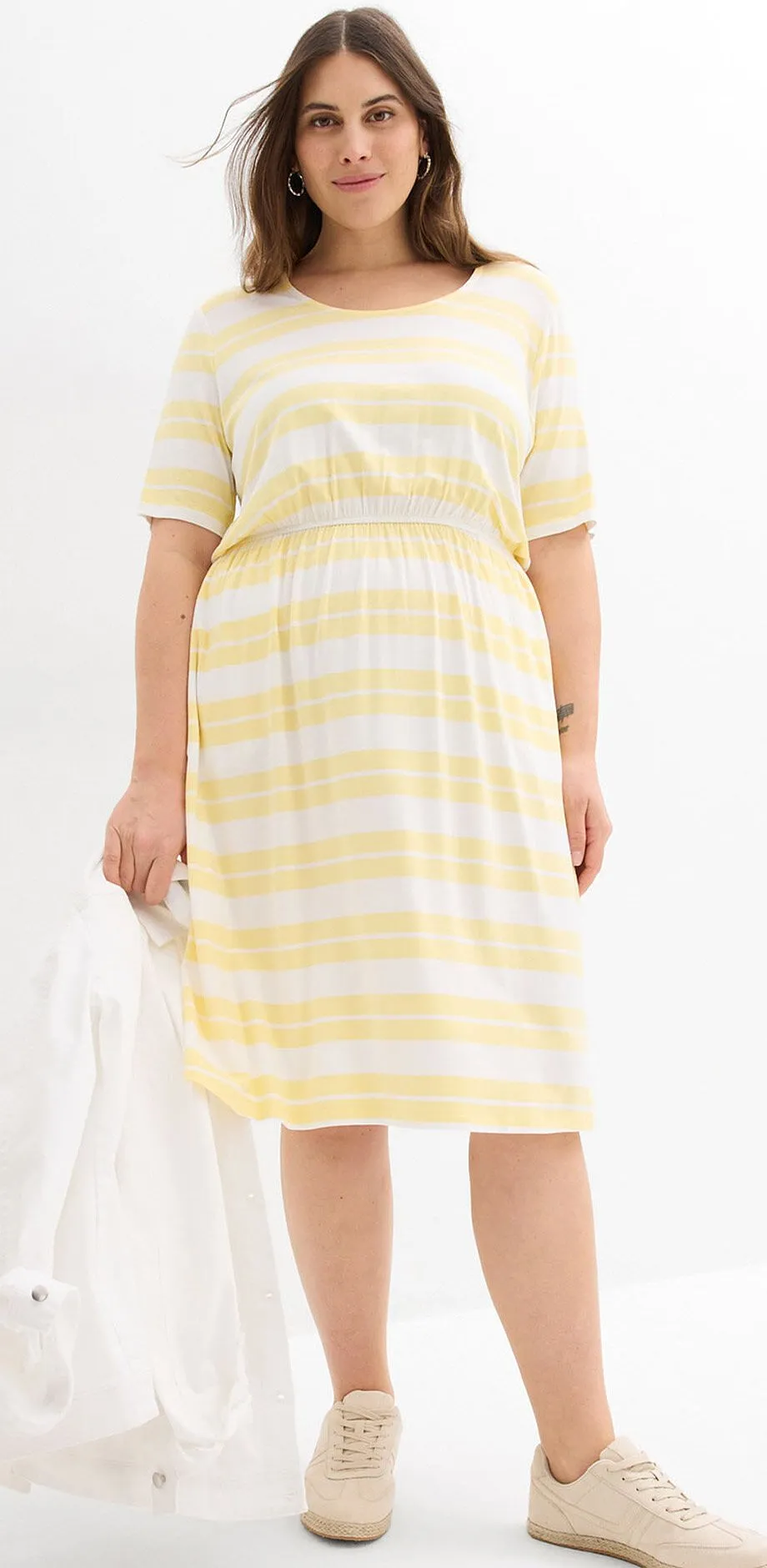 Robe jaune clair &agrave; rayures et sneakers beige.