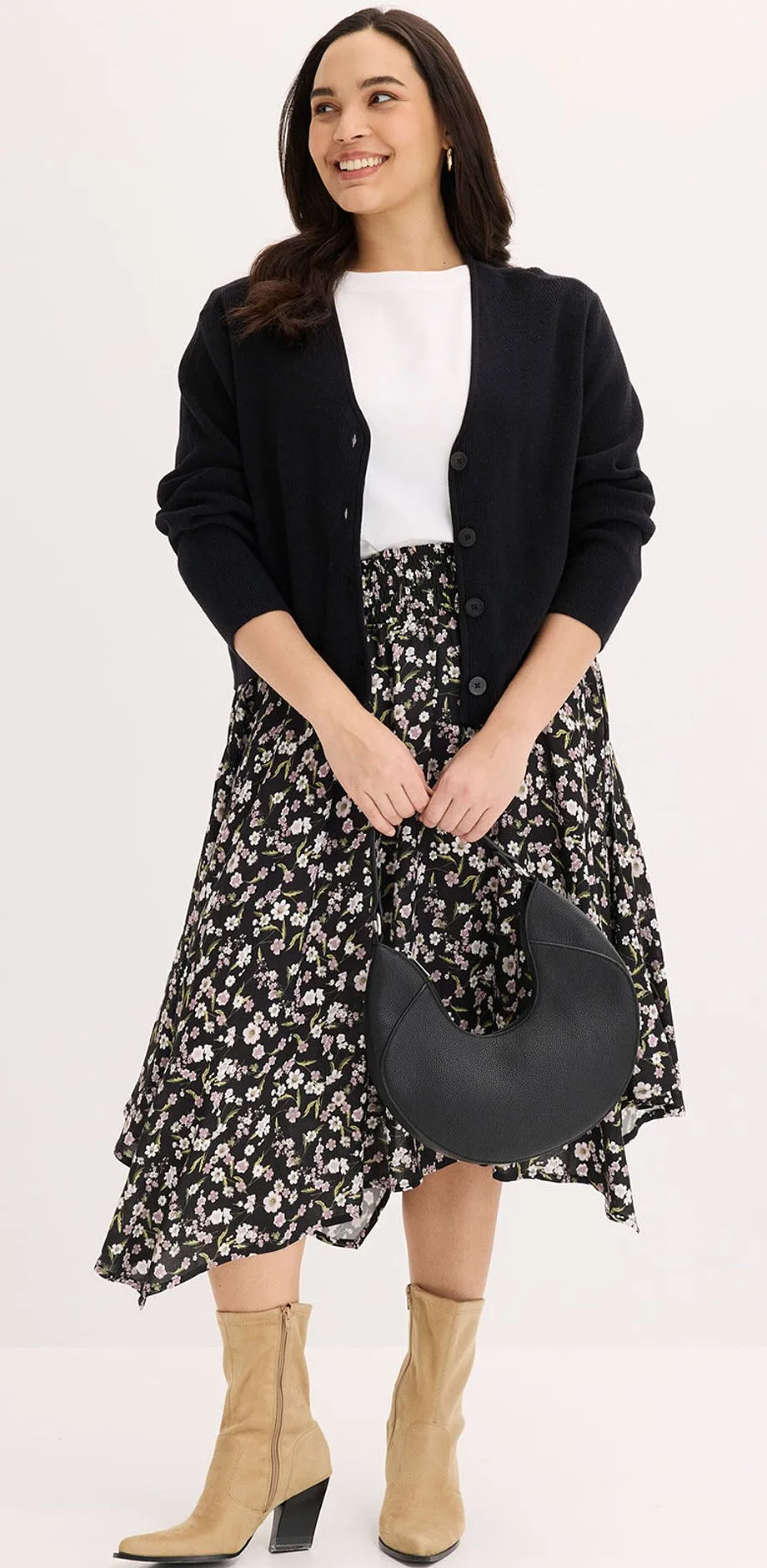 Gilet en maille noir, T-shirt blanc et jupe midi &agrave; motif en noir et blanc.