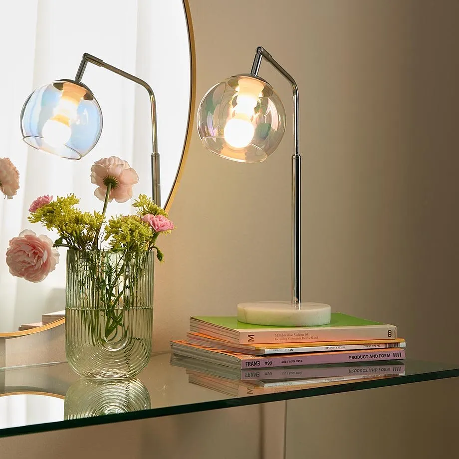 Lampe de table &eacute;l&eacute;gante avec abat-jour en verre &eacute;clairant un salon moderne dans des tonalit&eacute;s chaleureuses.