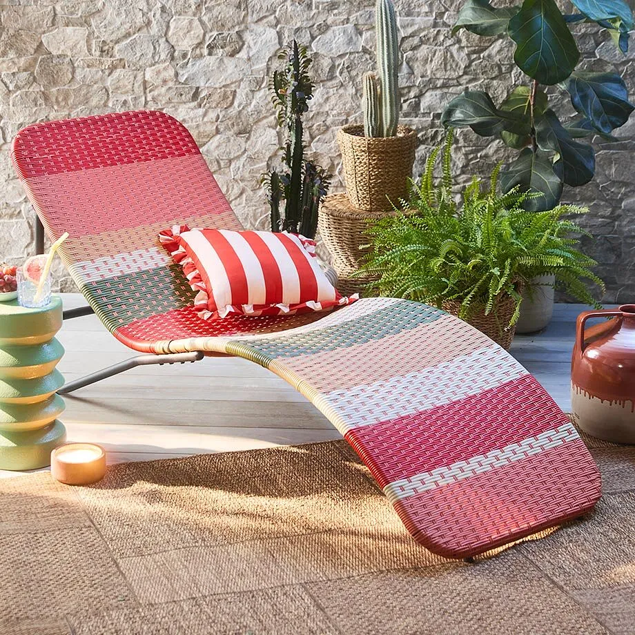 Coussin ray&eacute; rouge et blanc sur une chaise longue, une douce invitation &agrave; la d&eacute;tente pour les beaux-jours.