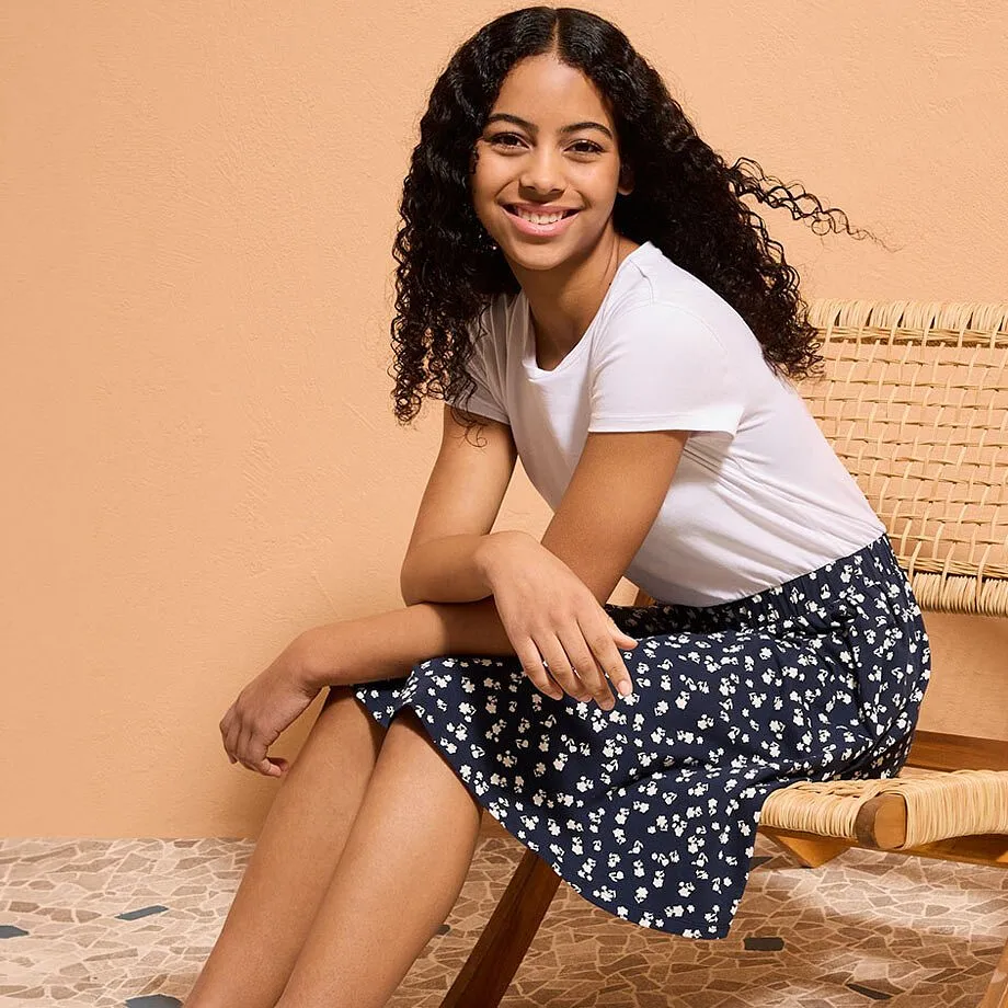 T-shirt blanc et jupe bleu fonc&eacute; &agrave; imprim&eacute; petites fleurs blanches.