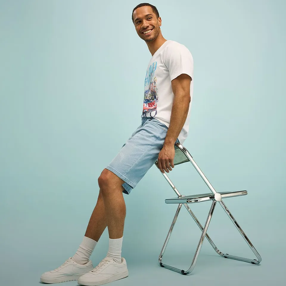 Look d&eacute;contract&eacute; avec T-shirt blanc, short bleu clair et sneakers blanches.