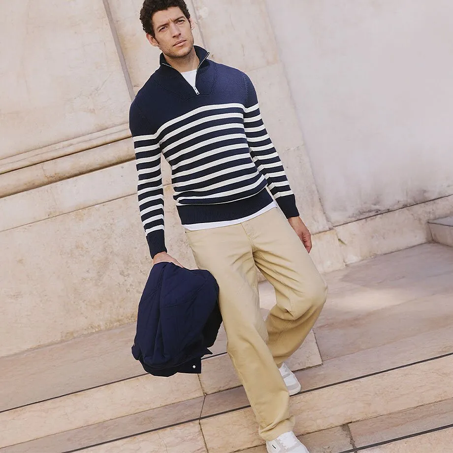 Gestreifter Pullover in Marineblau und Wei&szlig;, beige Hose und dunkelblaue Jacke.