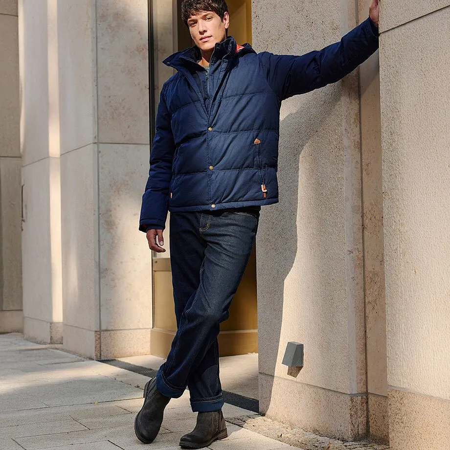 Dunkle Jeans und robuste Stiefel erg&auml;nzen die warme Winterjacke.