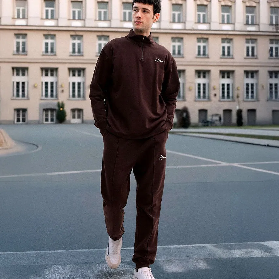 Dunklelbrauner Trainingsanzug  wei&szlig;e Sneaker.