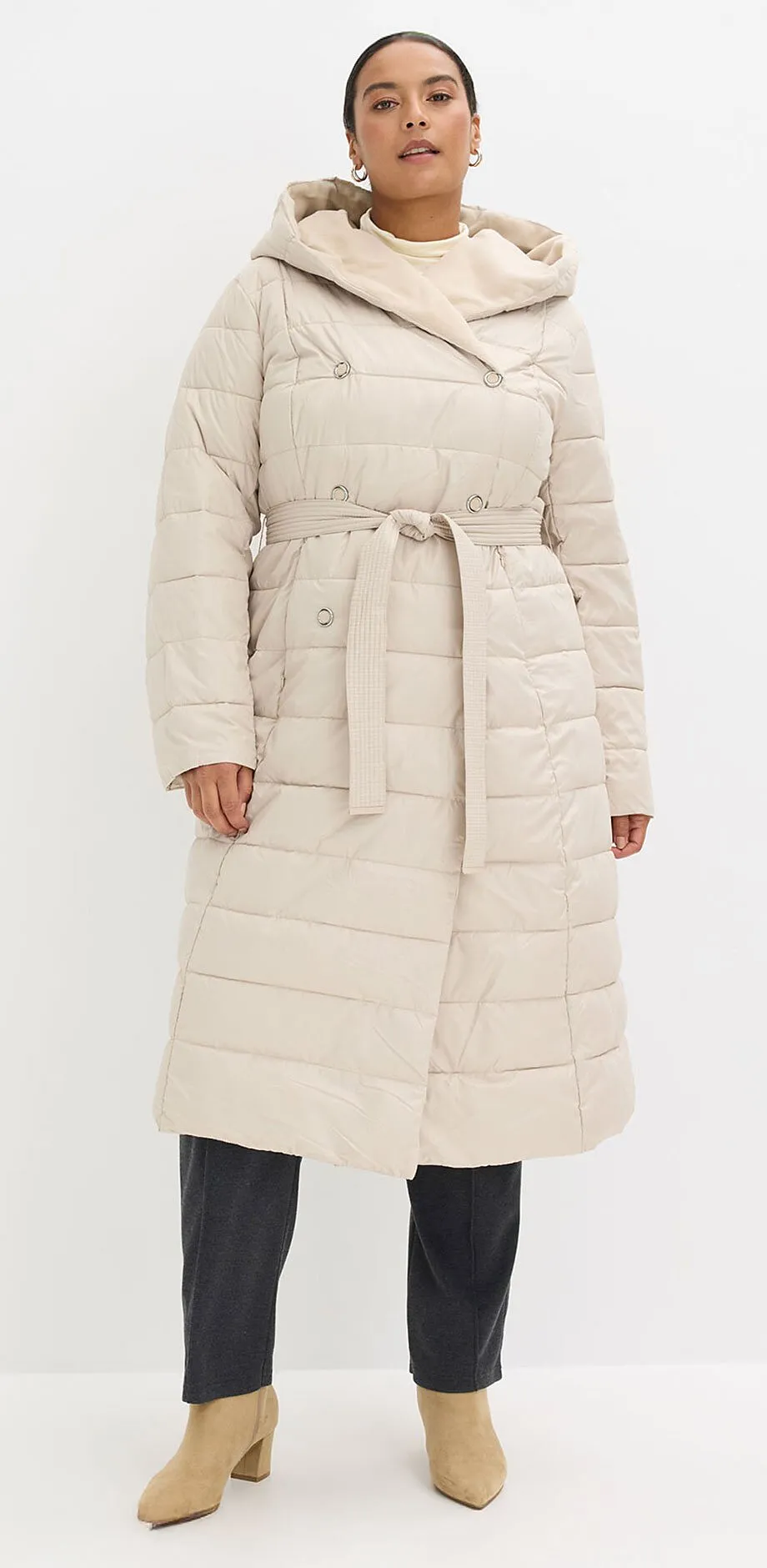 Manteau matelass&eacute; couleur cr&egrave;me avec capuche et ceinture.