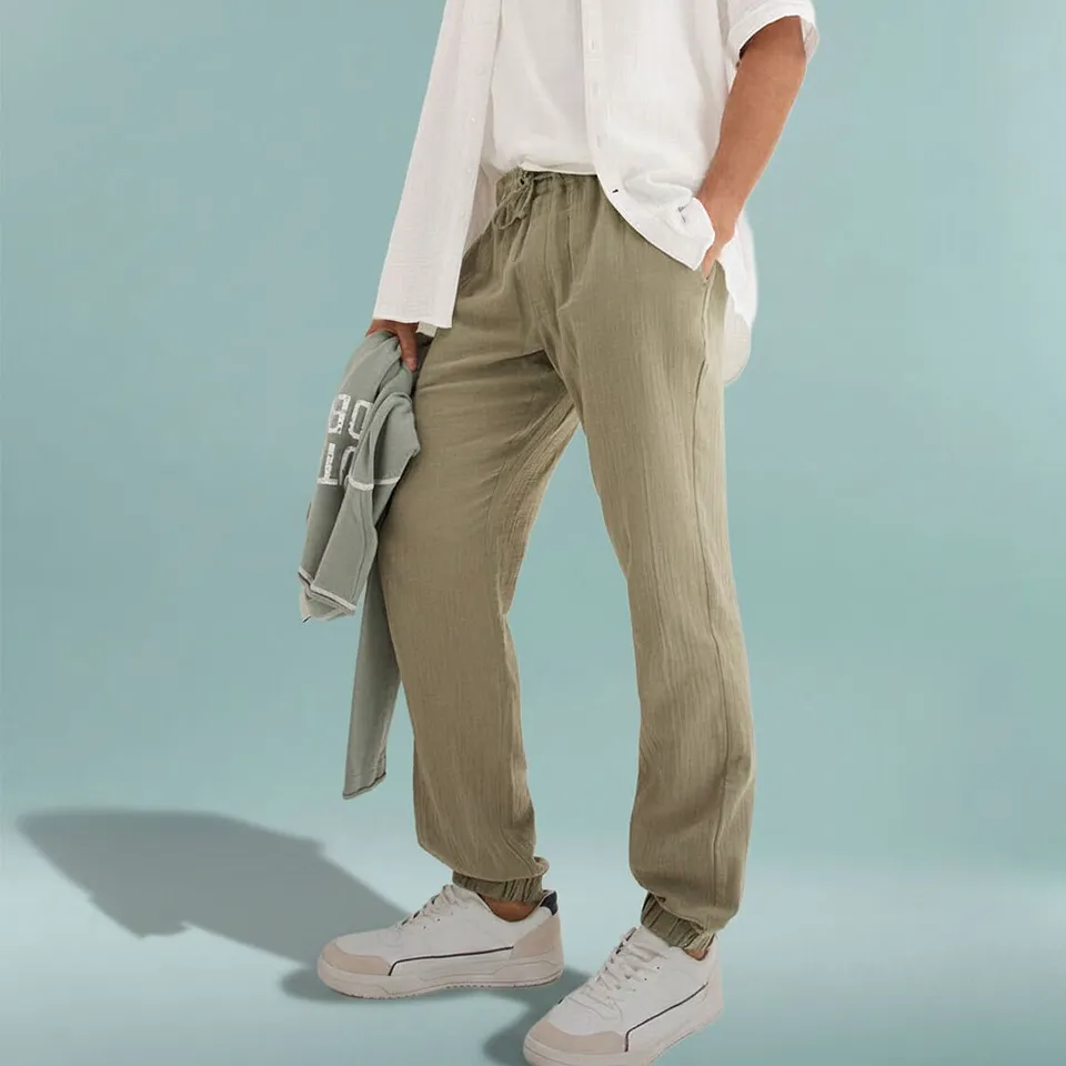 Pantalon d&eacute;contract&eacute; vert olive avec T-shirt blanc et chemise claire.