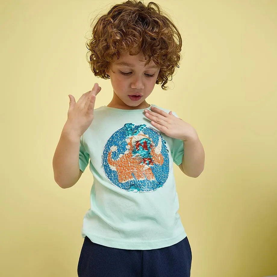 Kind tr&auml;gt ein t&uuml;rkises T-Shirt mit buntem Aufdruck.