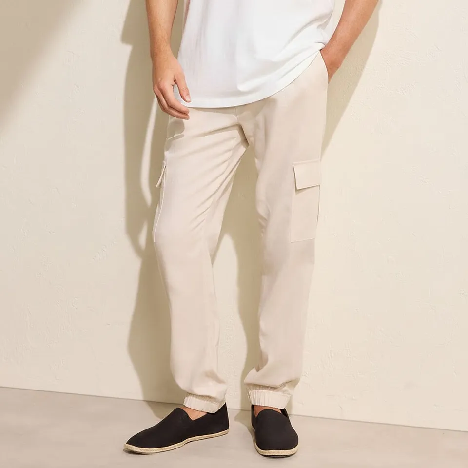 L&auml;ssiger Look mit wei&szlig;em T-Shirt, beigen Cargohosen und dunklen Slip-on Schuhen.