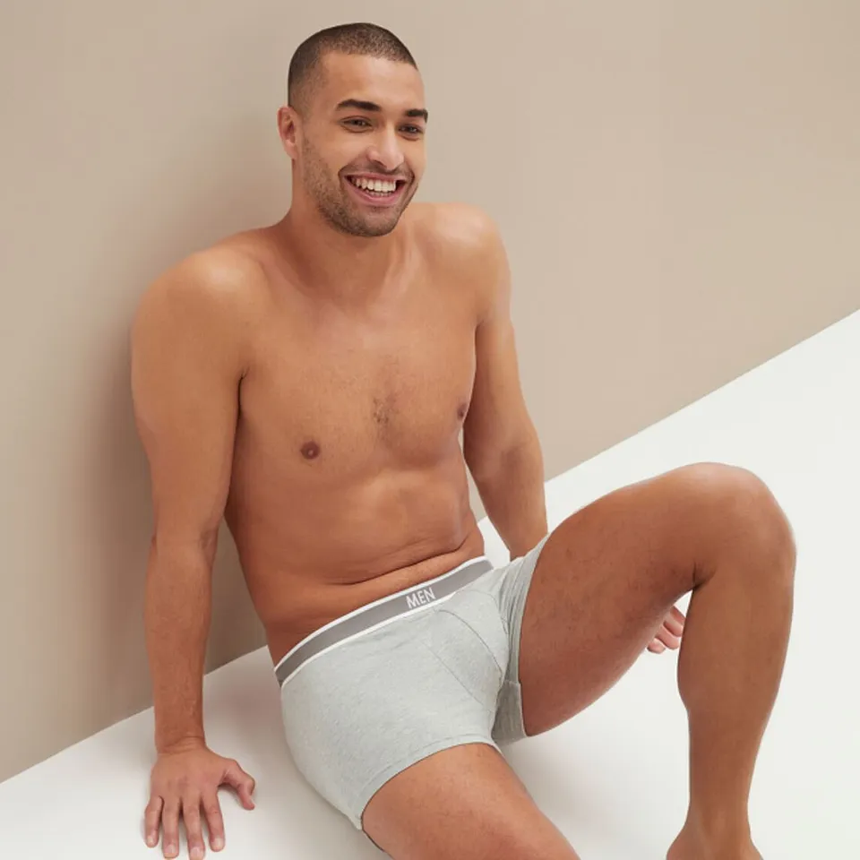 Mann tr&auml;gt graue Boxershorts mit elastischem Bund.