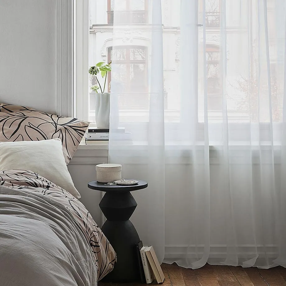Des voilages blancs transparents d&eacute;corent la fen&ecirc;tre.