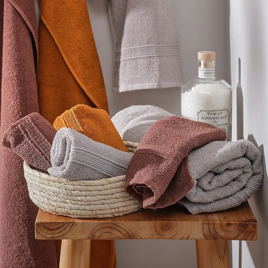 Serviettes de toilette douillettes dans des tons chauds - orange, beige et gris en parfaite harmonie.