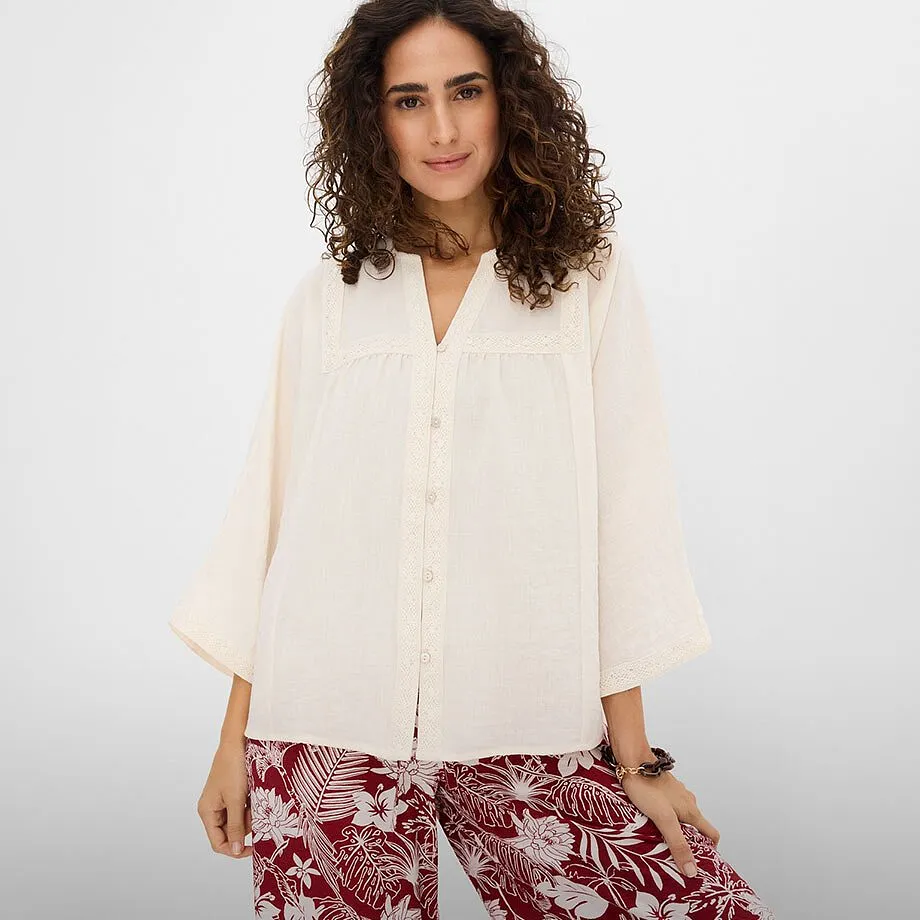 Chemisier blanc &eacute;l&eacute;gant associ&eacute; &agrave; un pantalon imprim&eacute; en rouge et blanc.