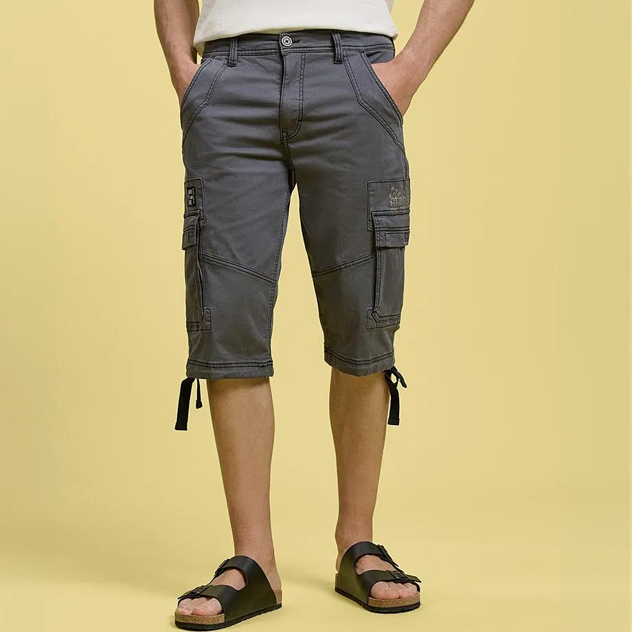 Graue Cargo-Shorts mit praktischen Seitentaschen, wei&szlig;es T-Shirt und schwarze Sandalen.