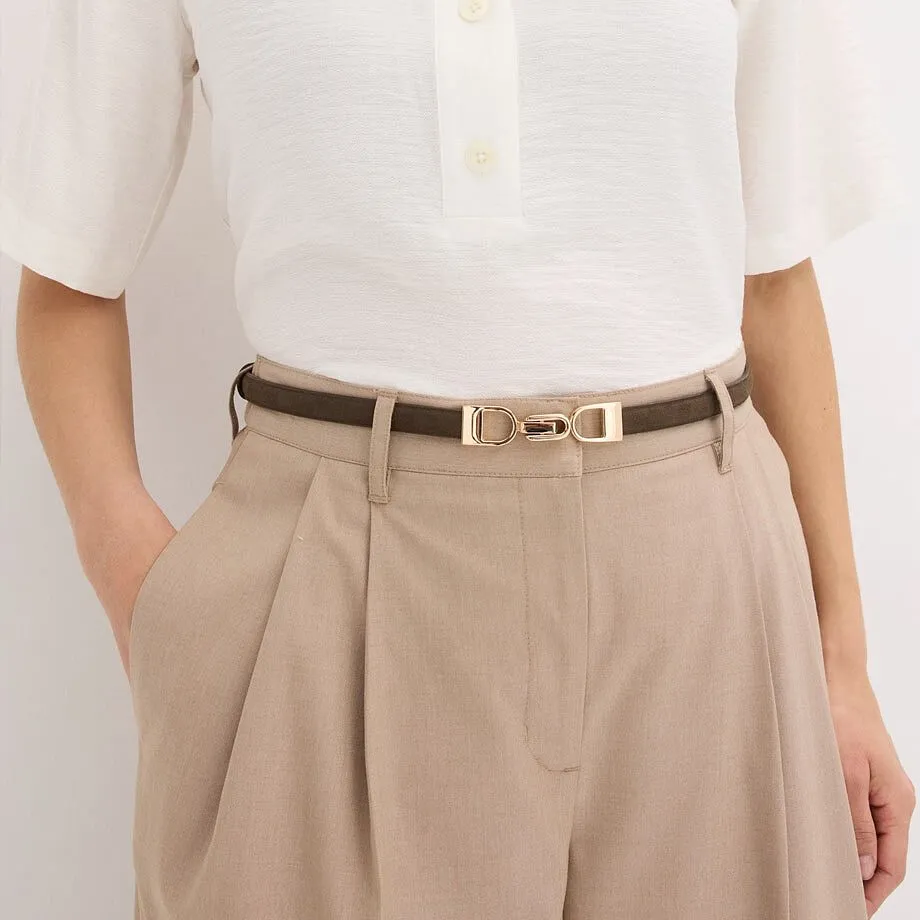 Chemisier blanc, ceinture fine avec boucle de couleur dor&eacute;e et pantalon beige.