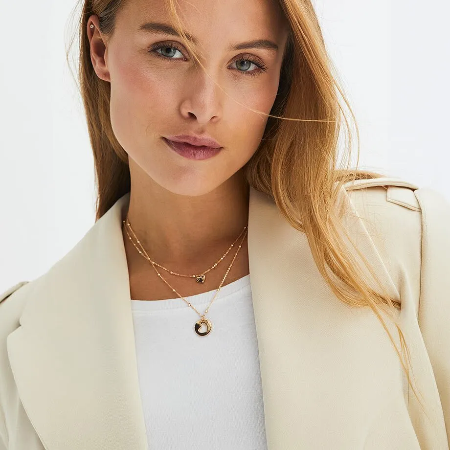 Une femme portant un blazer beige et un collier-cha&icirc;ne.