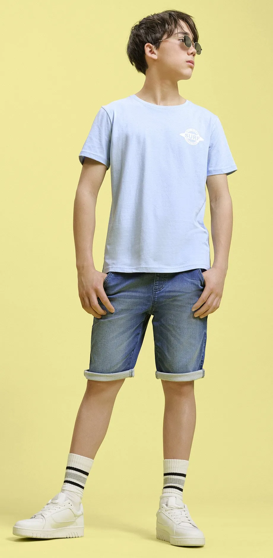 T-shirt bleu clair et short en jean.
