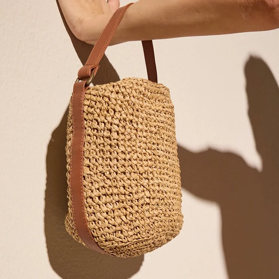 Sac en paille tress&eacute;e avec des touches de cuir.