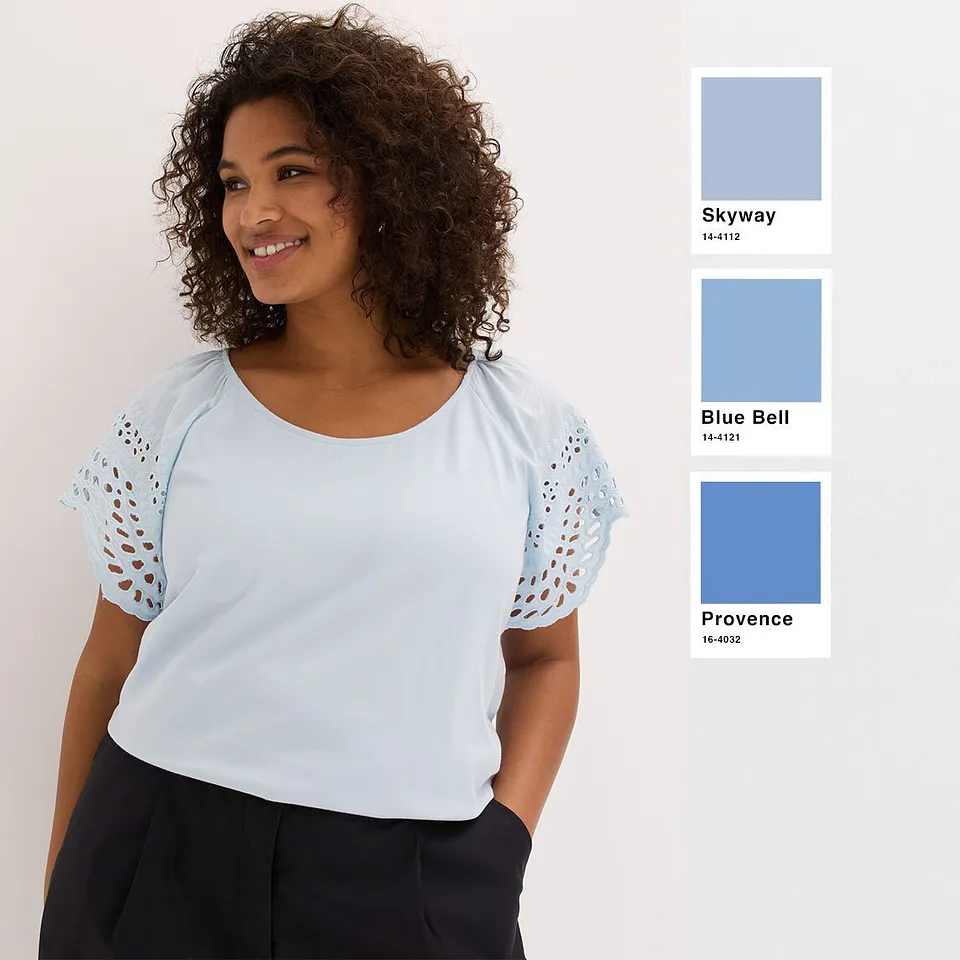 Haut bleu clair rafra&icirc;chissant avec manches ajour&eacute;es, associ&eacute; &agrave; un pantalon basique de couleur fonc&eacute;e.