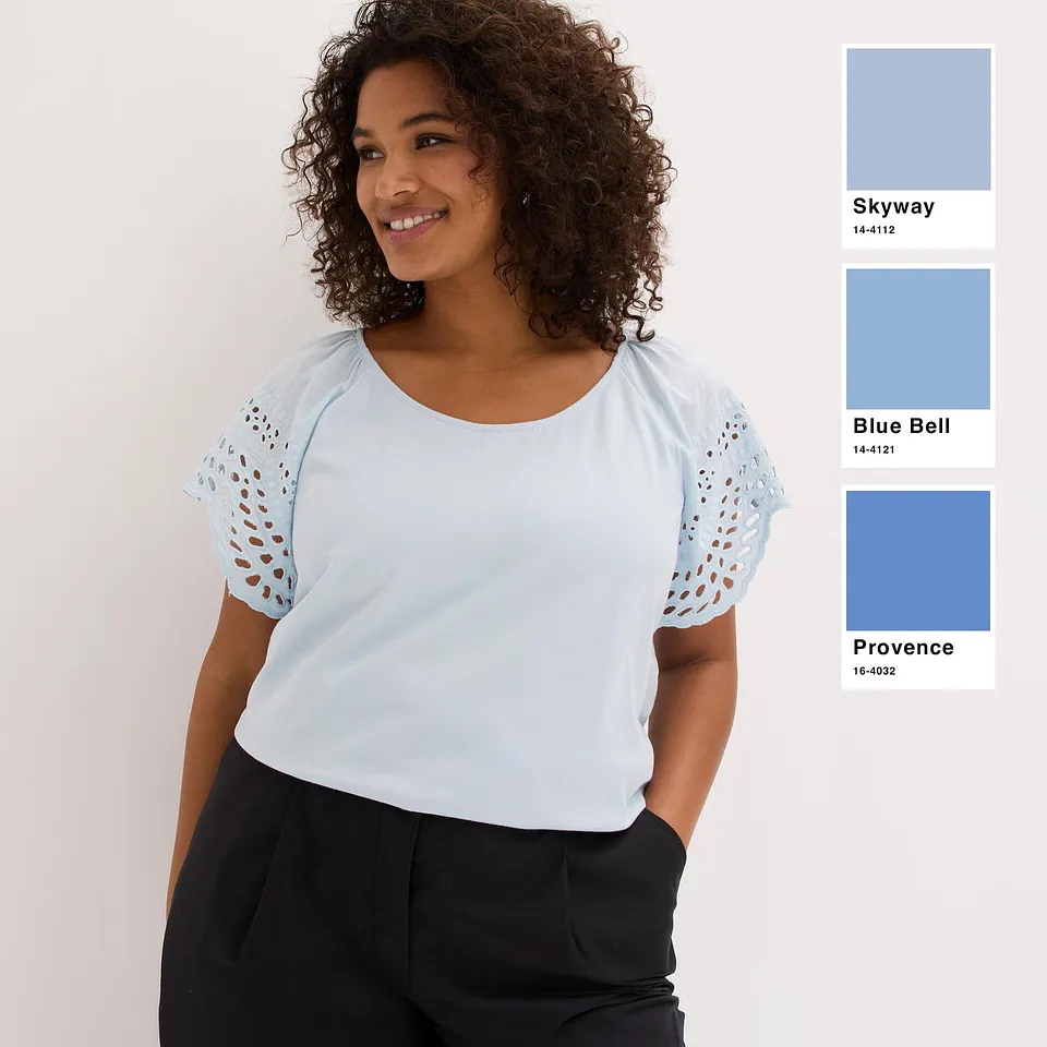 Haut bleu clair rafra&icirc;chissant avec manches ajour&eacute;es, associ&eacute; &agrave; un pantalon basique de couleur fonc&eacute;e.