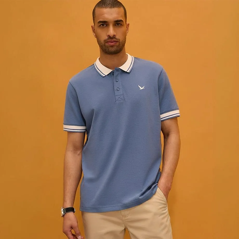 Blaues Poloshirt mit elegantem wei&szlig;en Kragen und passender beiger Hose.