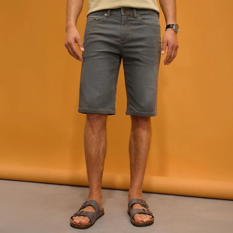 Graue Shorts, helles Shirt und bequeme Sandalen.