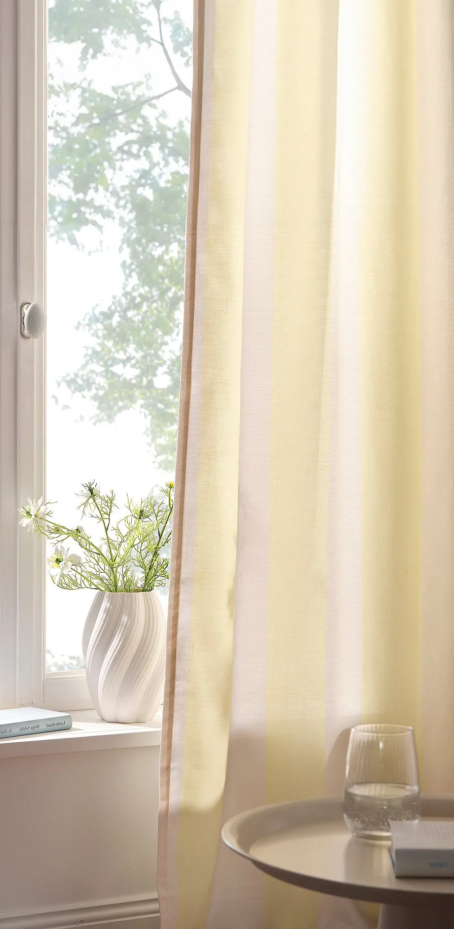 Voilages jaunes devant la fen&ecirc;tre.