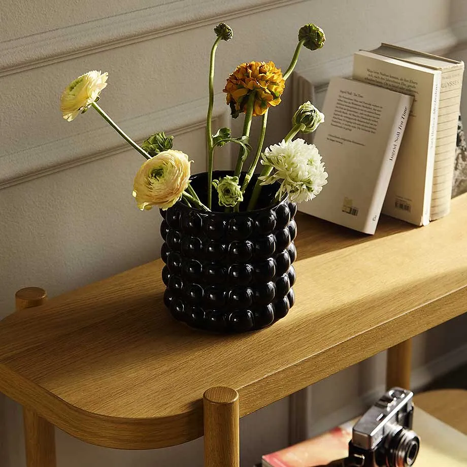 Fleurs dans un vase sur une table en bois.