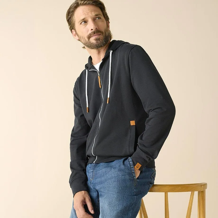 Dunkler Rei&szlig;verschluss-Sweatjacke, hellblaue Jeans, wei&szlig;es Shirt.