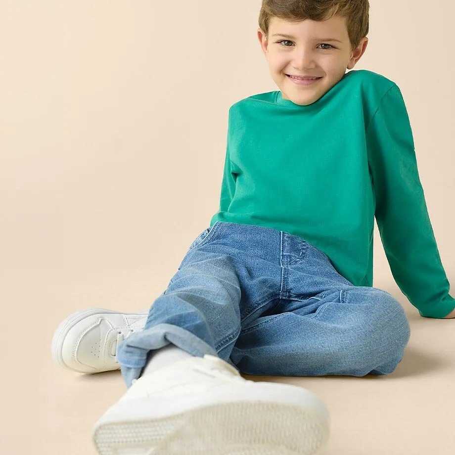 T-shirt vert &agrave; manches longues, jean bleu et sneakers blanches - une tenue confortable pour les enfants.