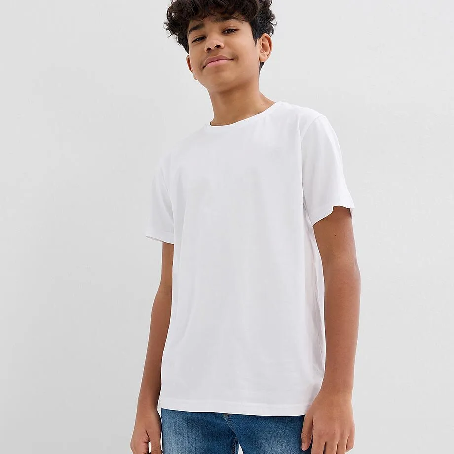 Gar&ccedil;on v&ecirc;tu d'un T-shirt blanc basique et d'un jean bleu confortable.