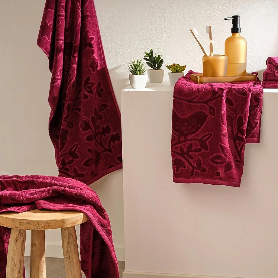 Des serviettes douillettes dans des tons rouge bordeaux apportent une touche cosy dans la salle de bain.