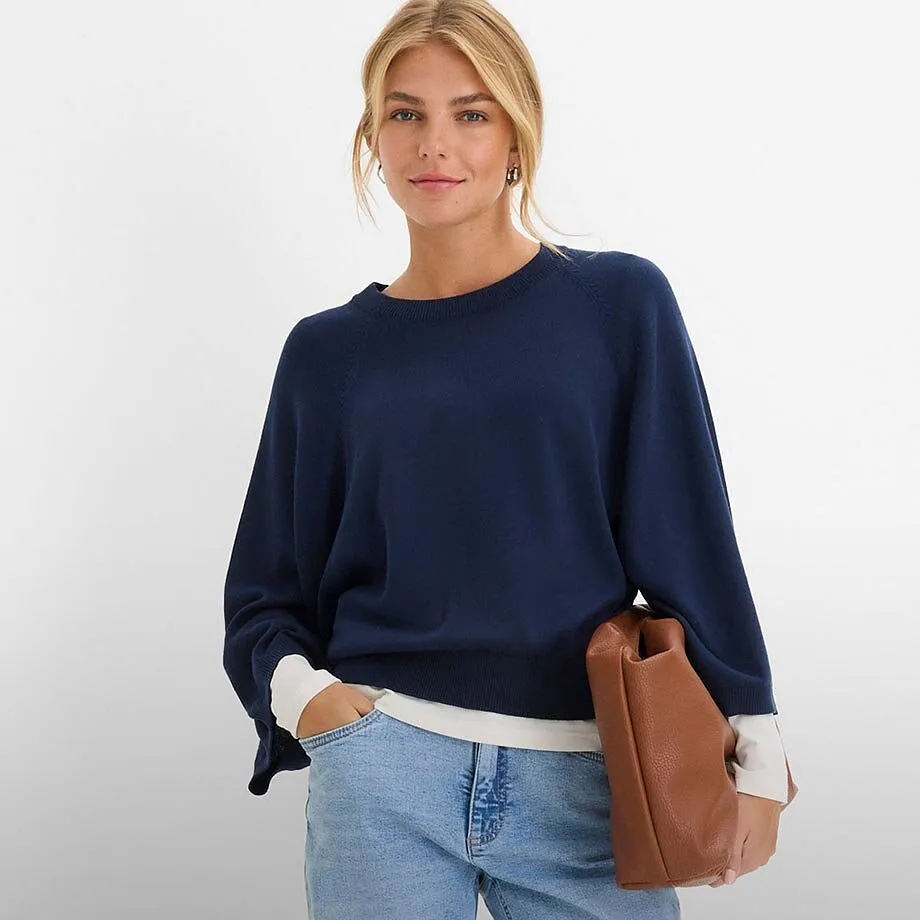 Pull bleu fonc&eacute;, jean clair et sac &agrave; main marron.