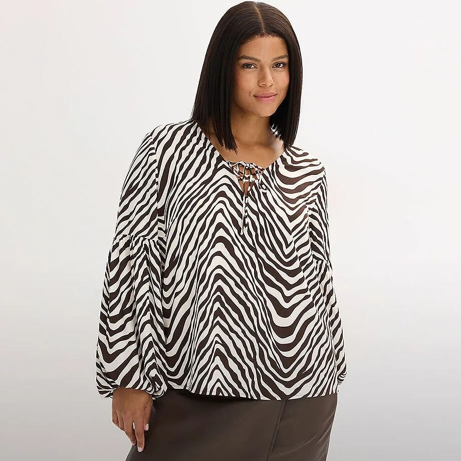 Blouse &agrave; motif z&eacute;br&eacute; et jupe de couleur fonc&eacute;e.