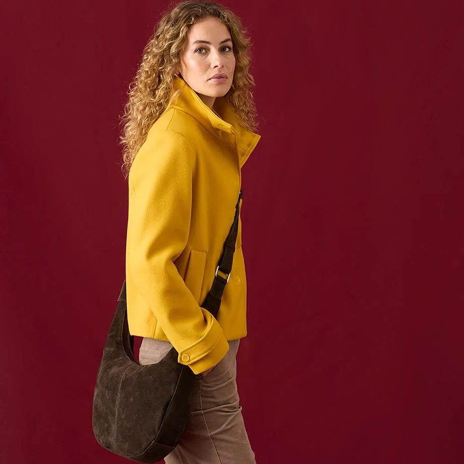 Une veste jaune mode associ&eacute;e &agrave; un pantalon marron et un sac &agrave; bandouli&egrave;re d&eacute;contract&eacute;.