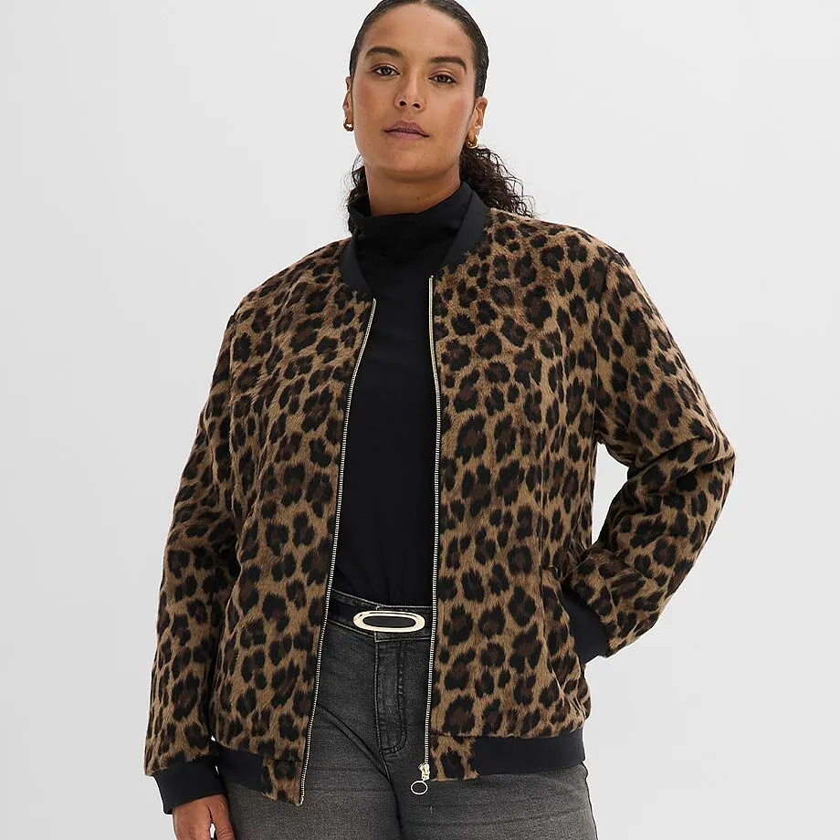 Veste bombers l&eacute;opard sur un pull &agrave; col roul&eacute; noir, associ&eacute;e &agrave; un jean gris et une ceinture &eacute;l&eacute;gante.