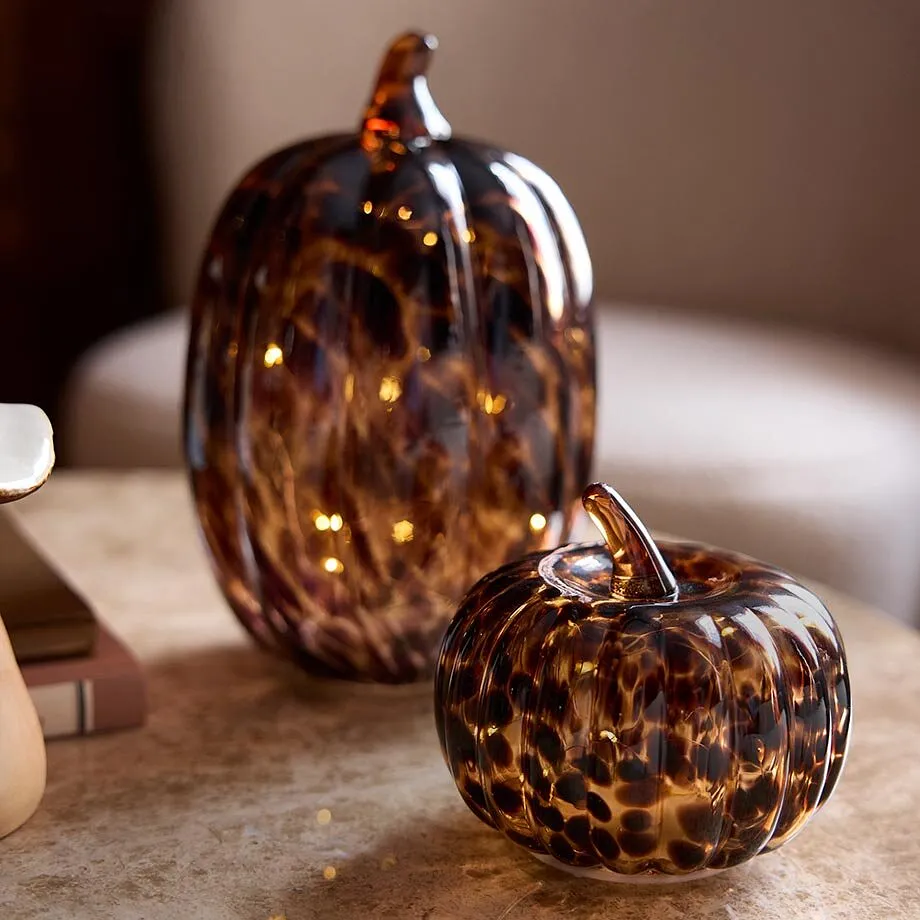 Deux citrouilles en verre avec une douce lumi&egrave;re chaude.