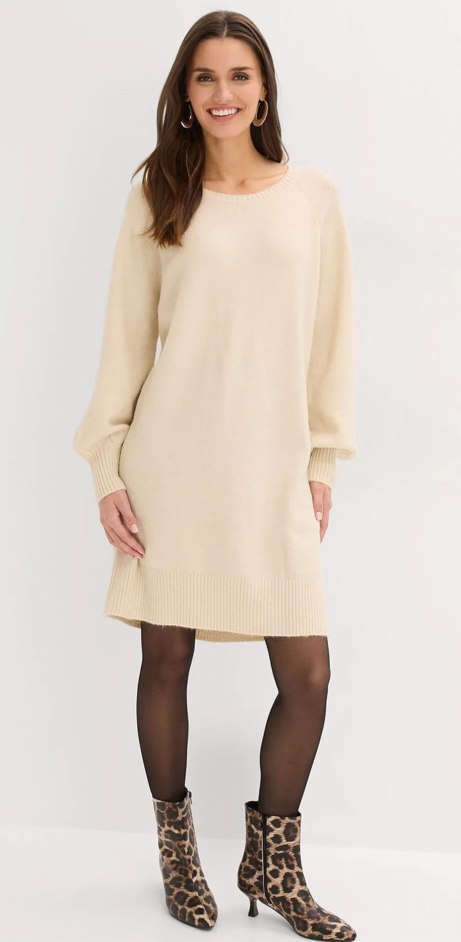 Cremefarbenes Strickkleid mit langen &Auml;rmeln.