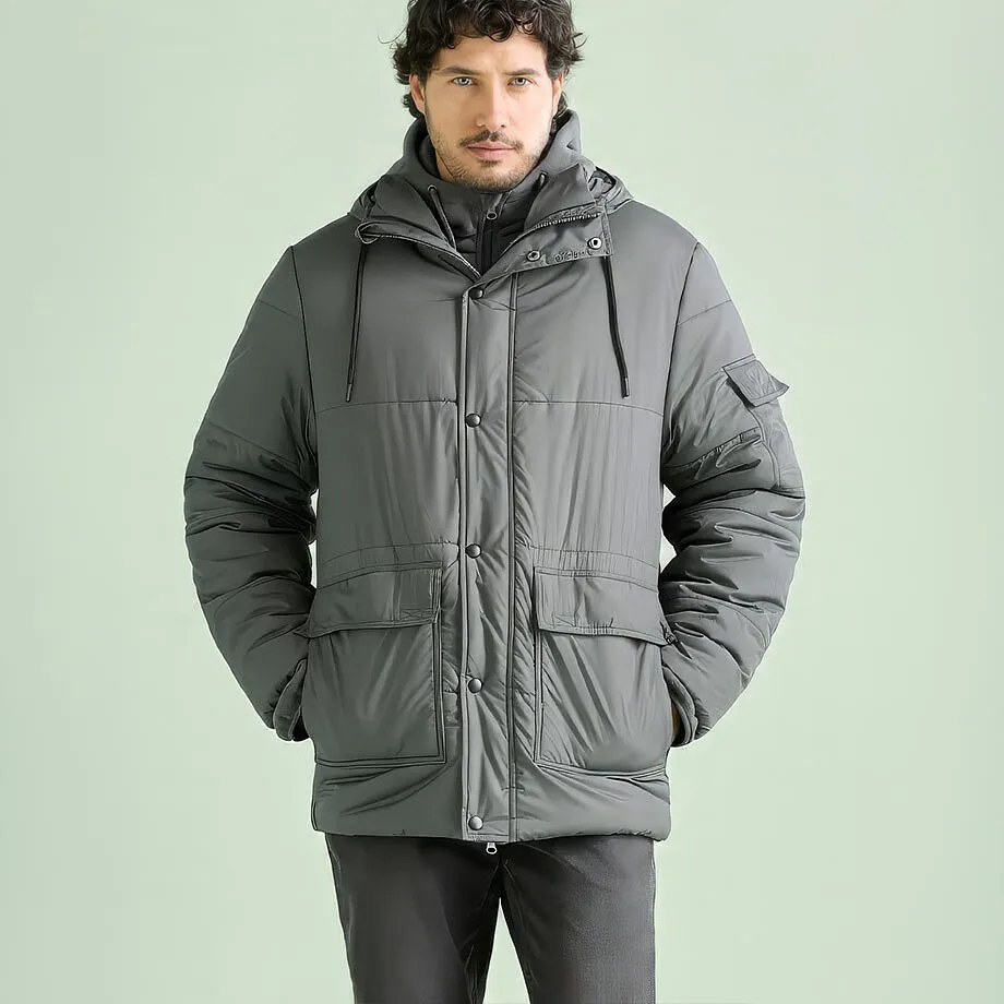 Mann tr&auml;gt eine graue, wattierte Winterjacke mit Kapuze und dunkler Hose.