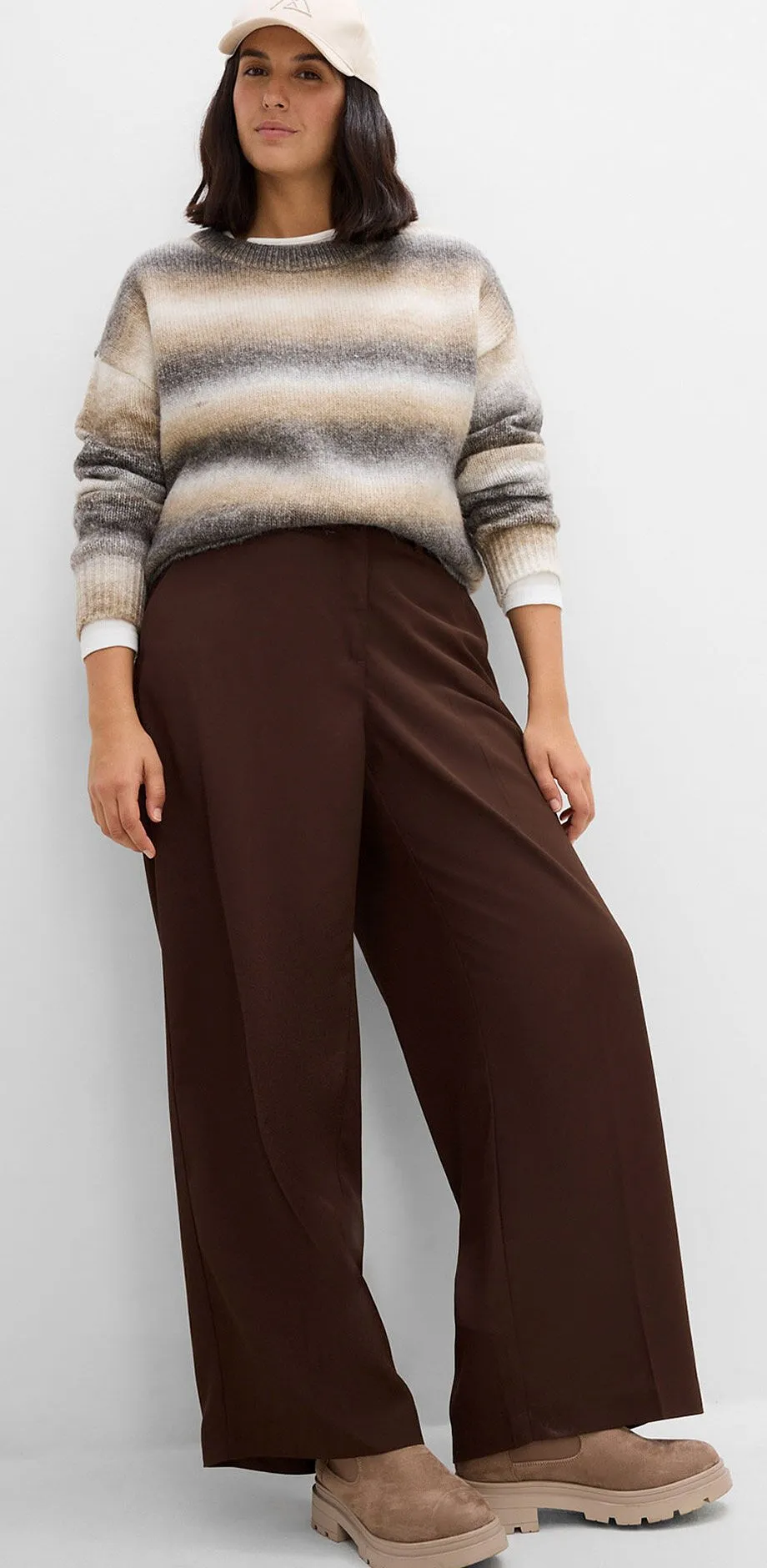 Pull &agrave; rayures, pantalon large marron, chaussures &agrave; plateforme confortables et casquette.