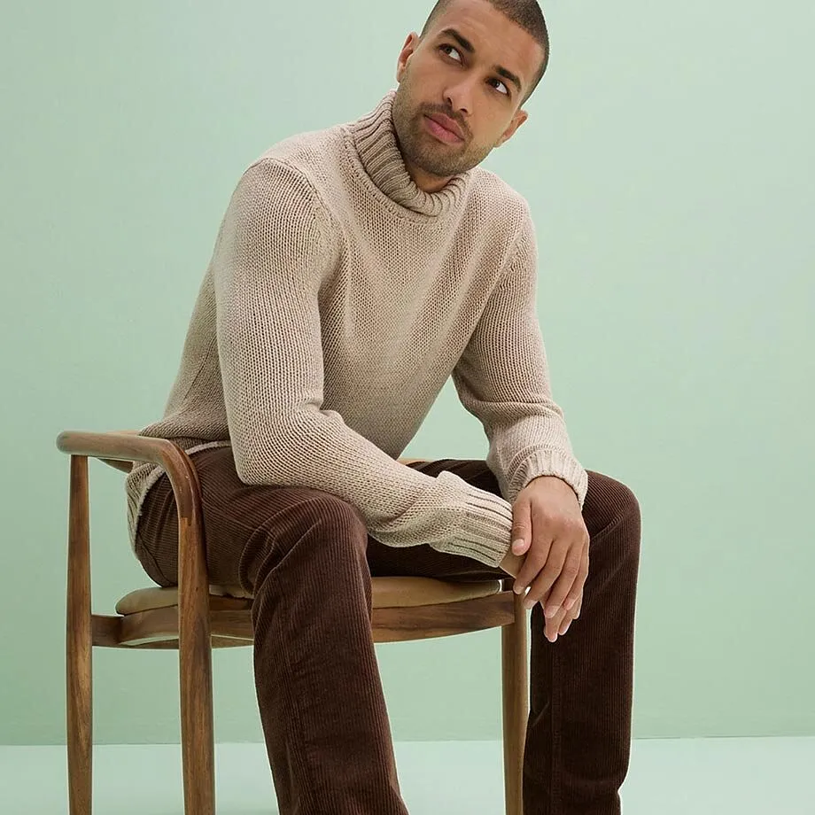 Un pull &agrave; col roul&eacute; douillet beige et un pantalon en velours c&ocirc;tel&eacute; marron.