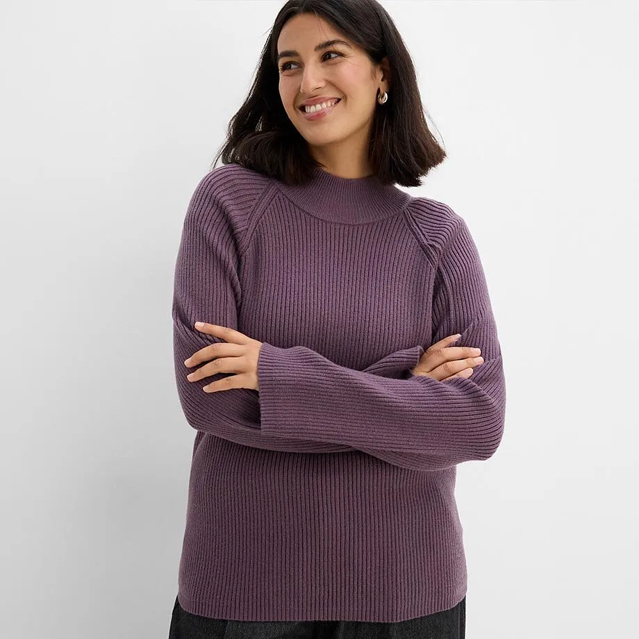 Pull en maille c&ocirc;tel&eacute;e lilas &agrave; col haut et pantalon fonc&eacute;.