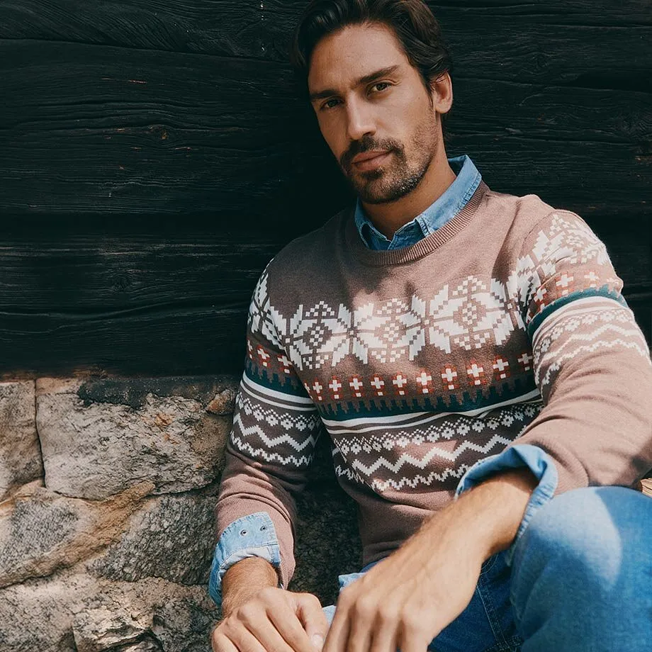 Norwegerpullover mit Schneeflockenmuster &uuml;ber Jeanshemd und Jeans.